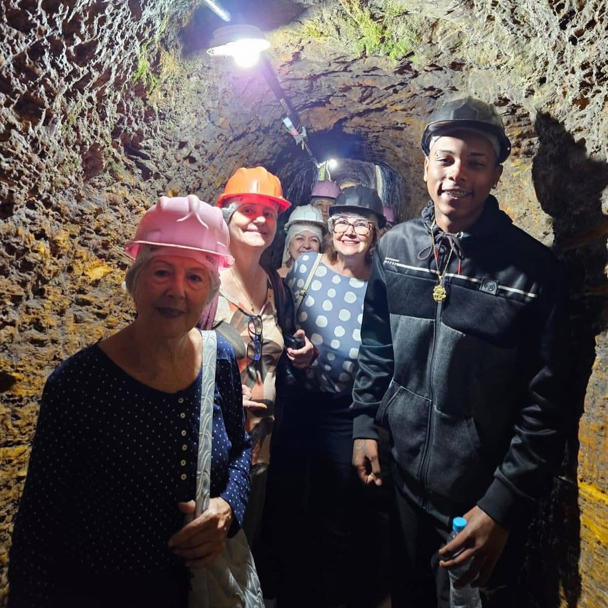 Viajantes de capacete visitando uma mina histórica