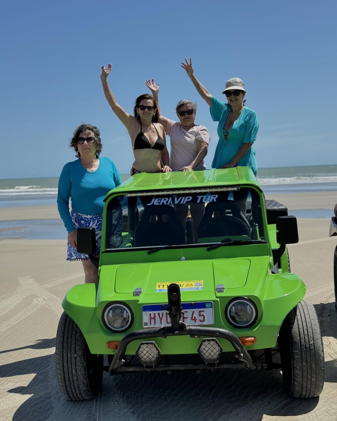 Viajantes comemorando em cima de um buggy na praia de Jericoacoara